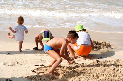 Kinder spieln am Strand beim Familienurlaub